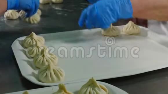国家格鲁吉亚美食Khinkali厨师手把饺子放在托盘上的特写镜头生的即食食品视频的预览图
