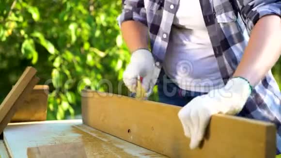 手工女用金属刷子在花园里刮木板的弯针视频的预览图