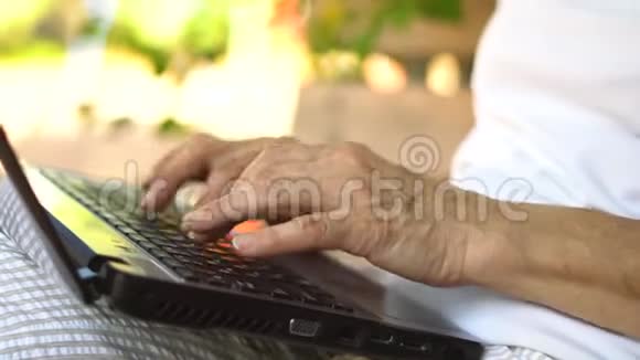 手的特写镜头中年妇女在户外工作手提电脑微笑的中年祖母在远处工作视频的预览图