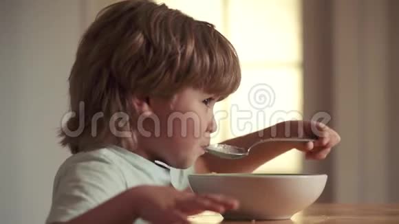 快乐的孩子吃早餐为孩子们提供食物和饮料可爱的孩子在家吃早餐小男孩吃早餐视频的预览图