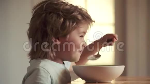 美丽的孩子在家吃早餐的肖像美味的儿童早餐坐在桌子上吃东西的小孩视频的预览图