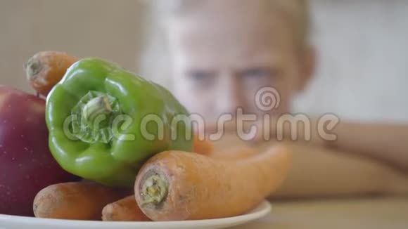 小女儿生气地看着盘子里的蔬菜因为她不想吃关门视频的预览图
