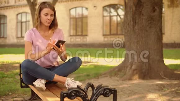 年轻女子在大学附近的手机上拍照视频的预览图