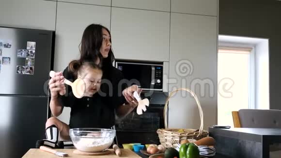 母亲和女儿穿着黑色T恤在厨房揉面视频的预览图