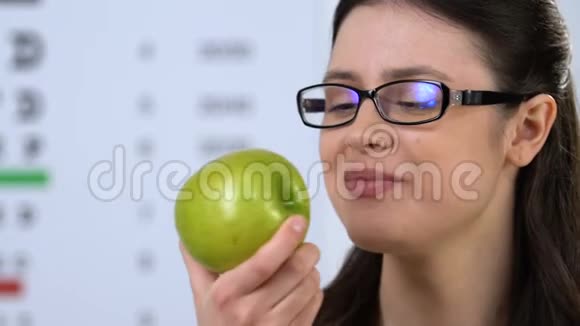 戴眼镜的开朗女人吃绿苹果健康节食维生素视频的预览图