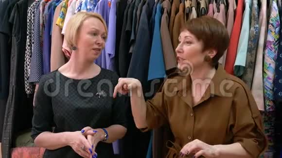 两位中年女性设计师在服装背景上谈论时尚潮流视频的预览图