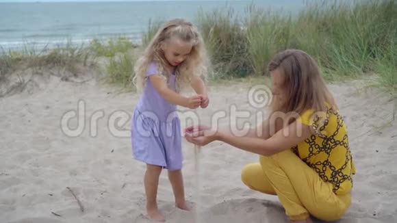 女儿和母亲在沙丘上玩沙子高加索家庭女孩视频的预览图
