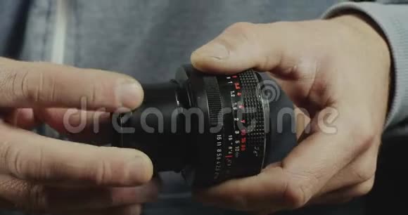男性手的特写镜头指向镜头的宏环摄影师将宏环安装到手动镜头电影4K录像视频的预览图