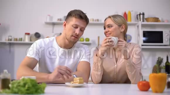 年轻人假装给女孩吃蛋糕夫妻在厨房里玩调情视频的预览图