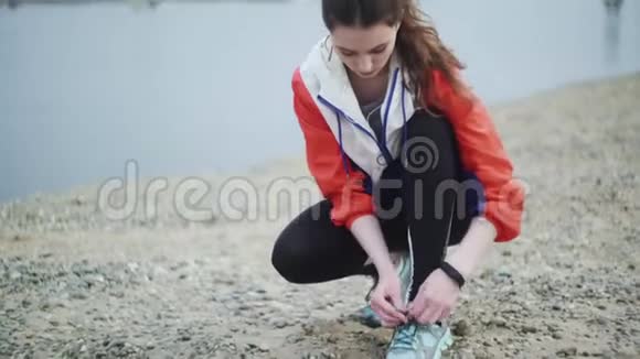 女人准备沿着河边的海滩跑步穿跑鞋的辣妹视频的预览图