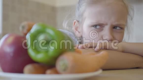 肖像小女儿愤怒地看着盘子里的蔬菜因为她不想吃它们关门视频的预览图
