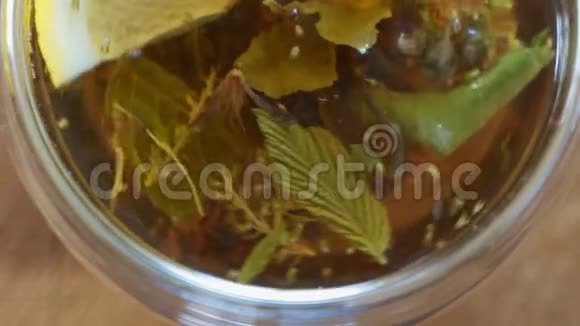 顶景特写茶叶在热水中开放透明杯煮熟口杯中冲泡绿茶或红茶视频的预览图