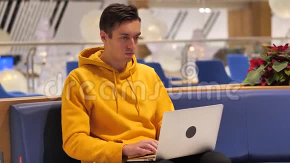 年轻人在一家现代化的大咖啡馆里手提电脑视频的预览图