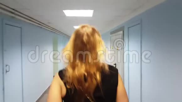 在医院空荡荡的走廊里散步的女人视频的预览图