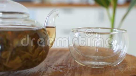 喝茶茶被倒入玻璃透明茶杯中喝茶的时候透明玻璃茶壶和茶杯视频的预览图
