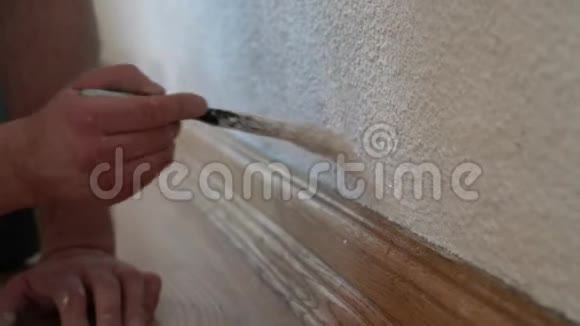 人的手使用油漆刷与白色油漆在墙壁内部视频的预览图