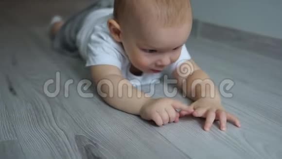 两岁的婴儿趴在地板上看着镜头亲密的肖像快乐的童年蓝眼睛视频的预览图