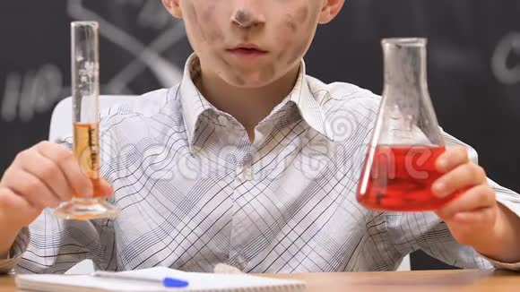困惑的小学生耸肩肮脏的脸经过化学实验视频的预览图