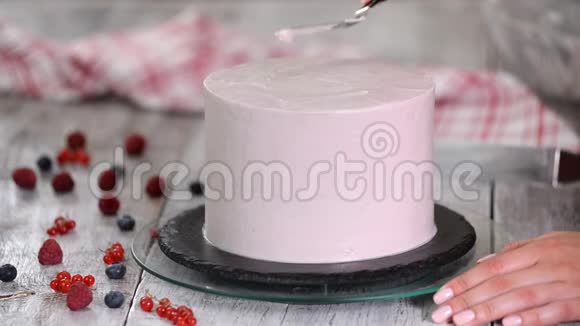 一步一步女人手在海绵蛋糕上撒鲜奶油面包师用抹刀做奶油蛋糕视频的预览图