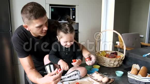 爸爸和小女孩穿着黑色T恤衫在厨房做饭视频的预览图