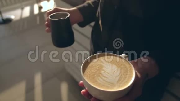 靠近咖啡师手里拿着芳香的卡布奇诺咖啡准备出售视频的预览图