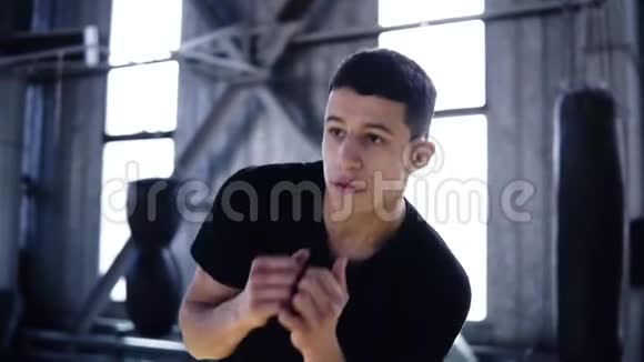 年轻运动员的慢动作镜头身穿黑色T恤的拳击手手臂热身身体自然地在健身房扭动视频的预览图