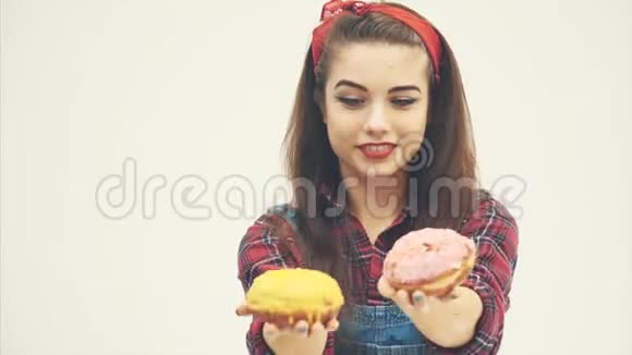 可爱的年轻女性伸出双手手里拿着甜甜圈对着镜头脸上的表情显示她们非常可爱视频的预览图