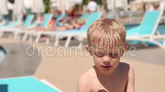一个小孩子在暑假在游泳池附近吃巧克力冰淇淋视频的预览图