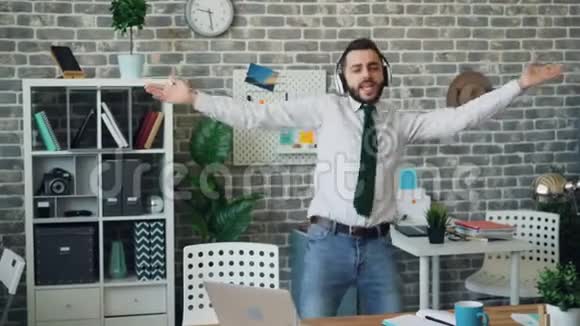 快乐的商人听音乐跳舞唱歌在办公室玩得开心视频的预览图