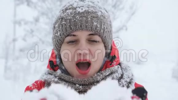 冬季娱乐理念女人开心地从手里吹出新鲜的雪视频的预览图
