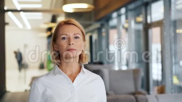 自信成熟的女人在咖啡馆里直视镜头的肖像视频的预览图