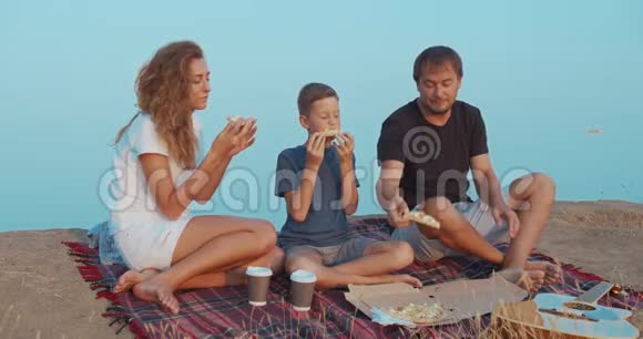 家庭积极沟通在山上野餐吃零食与咖啡和披萨视频的预览图