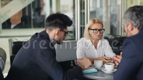 愉快的同事在咖啡馆里社交聊天和微笑享受咖啡休息视频的预览图