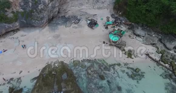 巴厘岛岩石海岸一艘蓝色小船残骸的空中镜头4k视频的预览图