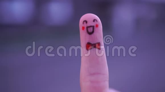 在中性背景下用黑色记号笔在指尖上画一张快乐的笑脸视频的预览图