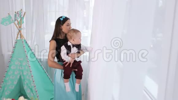 一个女人和一个小儿子在一个孩子的游戏室窗户附近的肖像视频的预览图