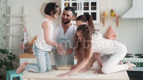 快乐的家庭在厨房做饭妈妈准备面团烘焙慢动作视频的预览图