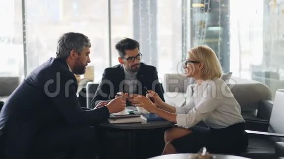 高级女商人向咖啡馆里的合伙人提供生意上的条件视频的预览图
