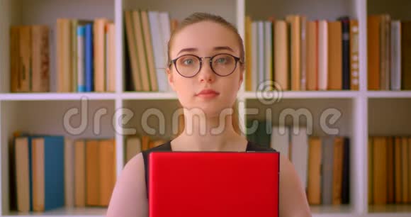 年轻的成功红发女商人戴着眼镜手里拿着笔记本电脑在办公室里的特写镜头视频的预览图