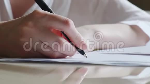 特写镜头女人在文件和邮票上签名慢动作太阳耀斑一个女人正在写笔视频的预览图