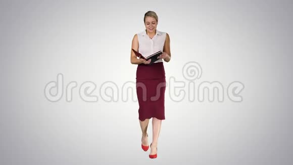 微笑的商务女性在梯度背景下阅读她的笔记视频的预览图
