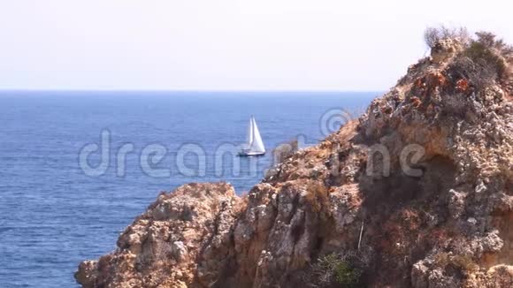 帆船游艇白色帆在开阔的大西洋躲向悬崖拉各斯阿尔加维葡萄牙视频的预览图