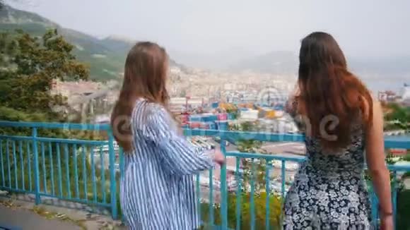 两个年轻的女人站在观点上说话关于城市的背景视频的预览图