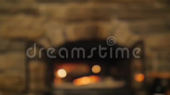 两只手拿着一杯红酒在燃烧的壁炉背景下在一个舒适的房子里庆祝视频的预览图