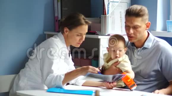 孩子和他父亲在儿科医生的约会医生开处方孩子玩处方视频的预览图