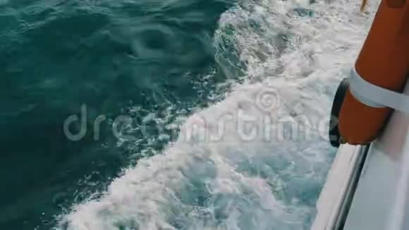 部分船舶和救生圈和美丽的绿松石海水与波浪和白色泡沫近距离俯视船视频的预览图