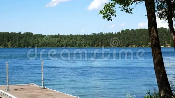 美丽的湖泊在明尼苏达州蓝天和水船坞和树在前景视频的预览图