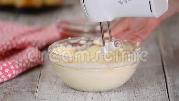 将白色奶油与马达搅拌器混合在碗中奶油中加入覆盆子酱视频的预览图