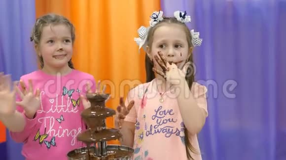 儿童游戏室孩子们吃巧克力喷泉里的巧克力视频的预览图