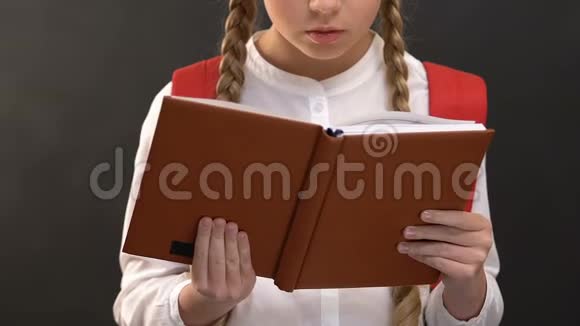 有背囊书的女学生靠在黑板上写作业视频的预览图